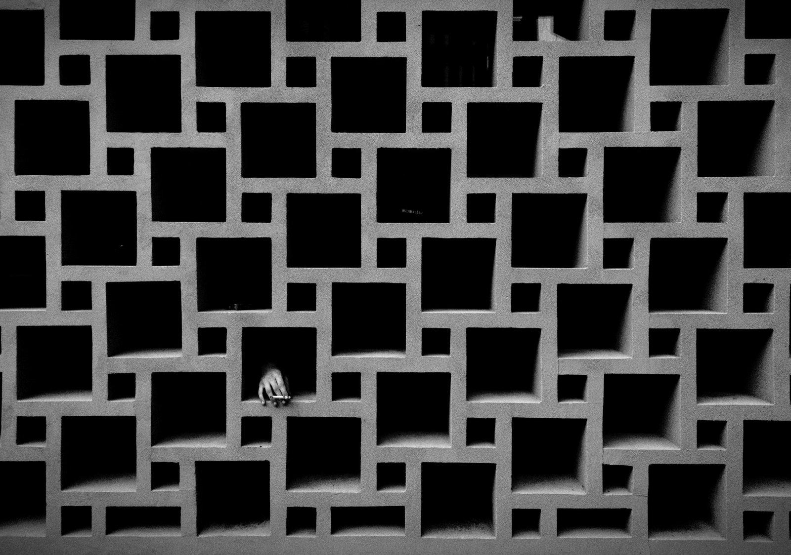 A striking black and white geometric pattern with a hand emerging, capturing both mystery and design.
